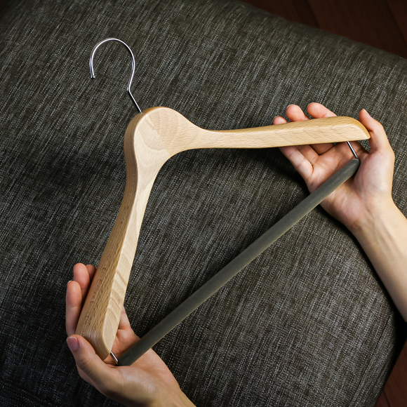 木製ハンガーを手に取る人物の手元