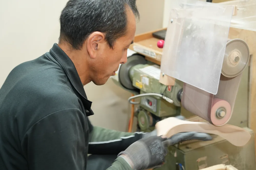 The refining process: sanding the wooden parts on a belt sander