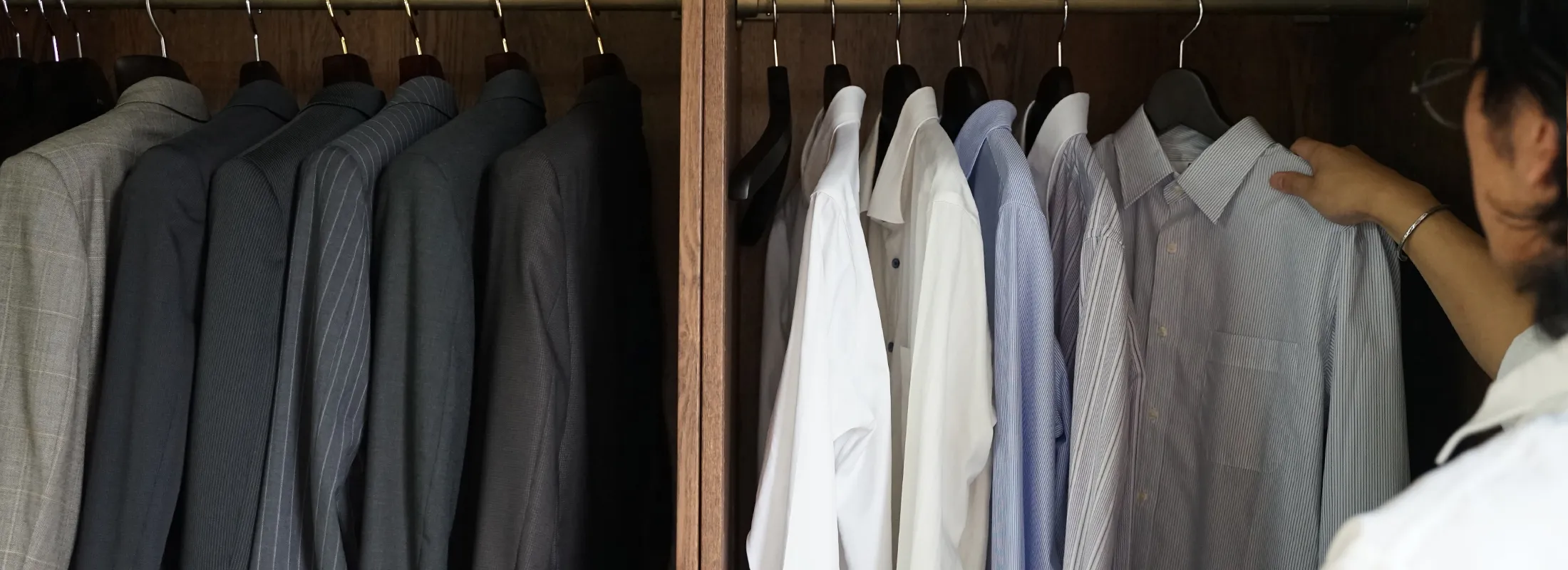 A man is choosing clothes from the closet